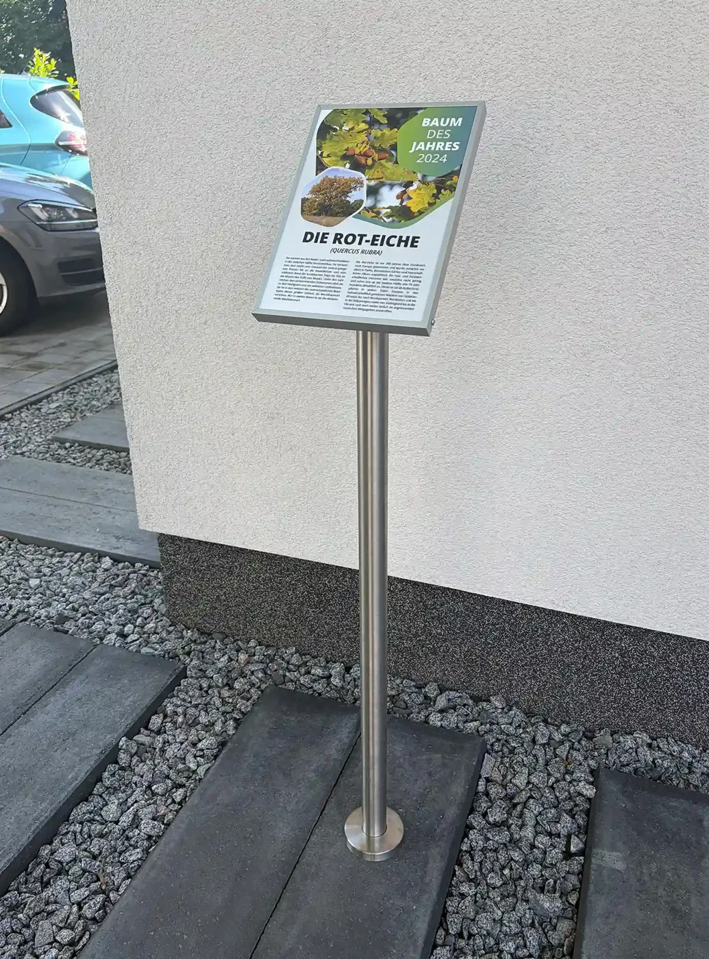 Edelstahl-Pultaufsteller mit Wechselrahmen und Flanschfuß auf gepflastertem Untergrund